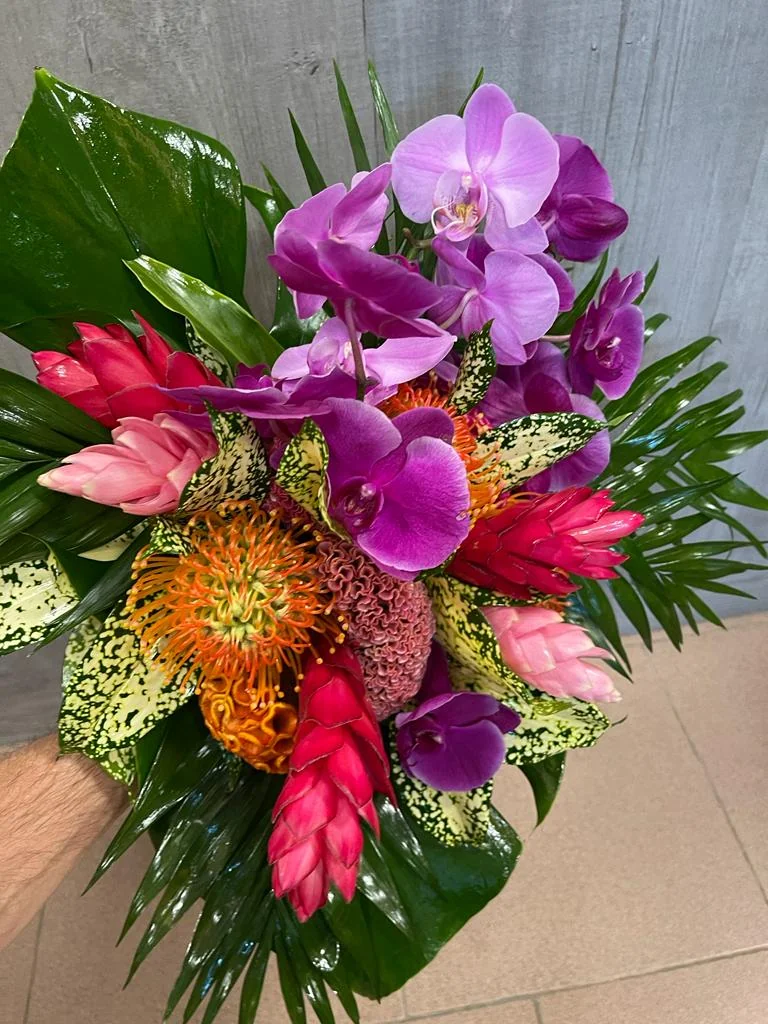Composizione con fiori tropicali nei toni del rosa, viola e arancio